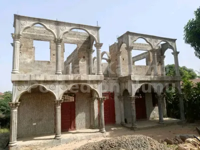An unfinished house sitting on a 2 plot of land